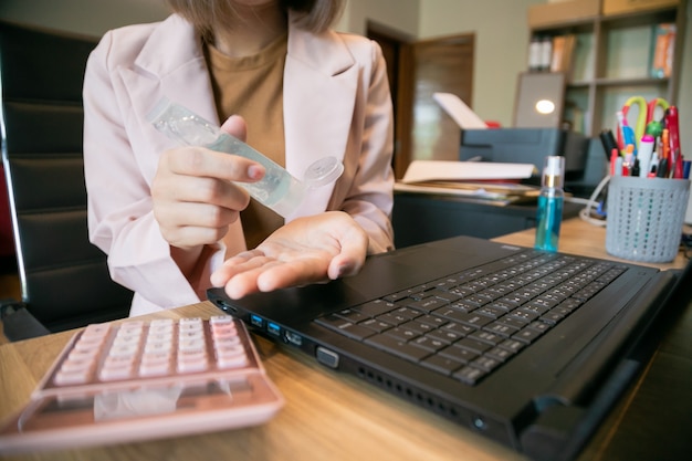 Coronavirus. Donna d'affari, lavoro da casa. Lavorare da casa. Lavarsi le mani con un gel disinfettante.