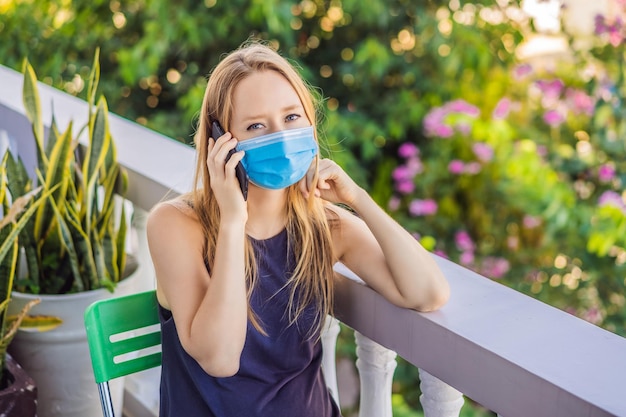 Coronavirus Donna in quarantena per coronavirus che indossa una maschera protettiva Lavora da casa e utilizza la videochiamata Videoconferenza