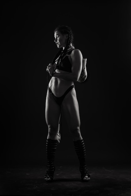 Corpo di donna abbronzata su sfondo grigio scuro
