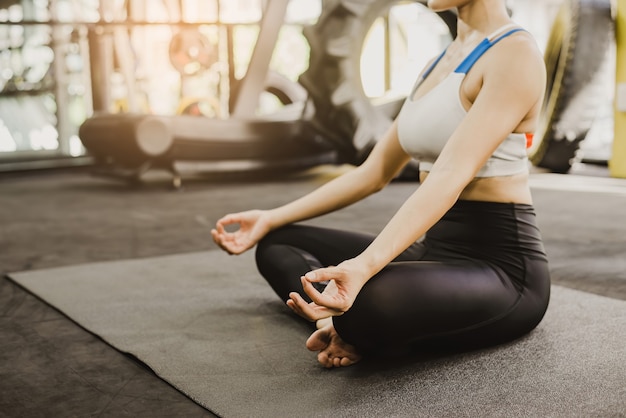 Corpo di figura femminile sana meditando nella postura yoga in palestra