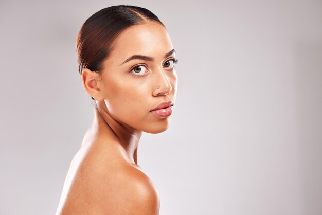 Corpo per la cura della pelle e ritratto di bellezza della donna seria per il marketing cosmetico naturale con viso sicuro e assertivo Benessere per la salute e modello pubblicitario della pelle luminosa con mockup da studio grigio