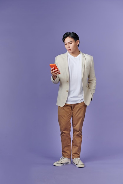 Corpo pieno giovane impiegato uomo d'affari tenere in mano utilizzare cellulare isolato su sfondo viola