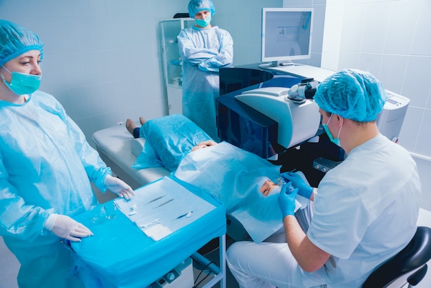 Correzione della visione laser. Un paziente e un team di chirurghi in sala operatoria durante la chirurgia oftalmica.