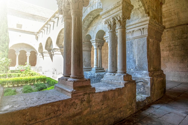 Corridoio con colonne bianche antiche illuminate dalla luce del sole