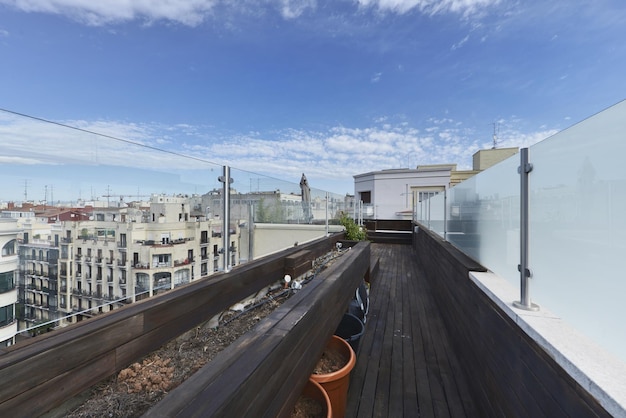 Corridoio con vasi di fiori e divisori in vetro con legno di acacia su tutti i lati sulla terrazza del sottotetto di una casa