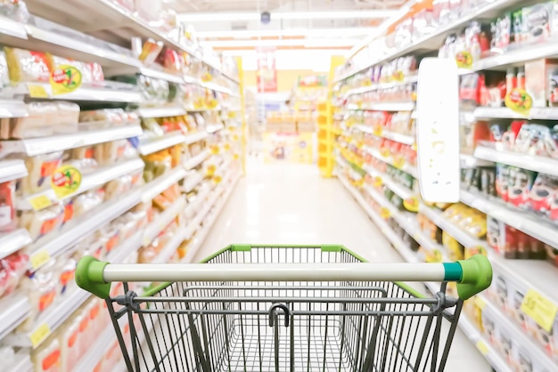 Corridoio del supermercato con il carrello verde vuoto