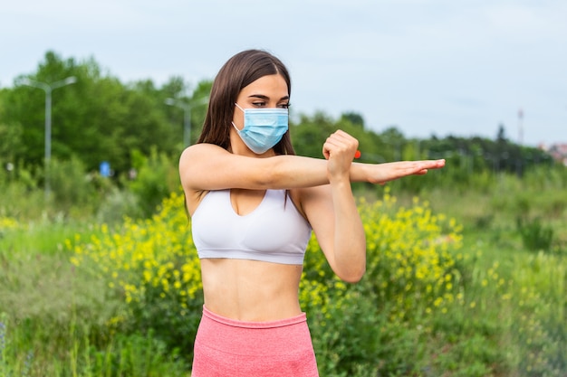 Corridore che indossa una maschera medica, pandemia di coronavirus Covid-19. Vita attiva nella protezione della maschera facciale sterilizzante chirurgica in quarantena. Corsa all'aperto in Corona Outbreak. Mantieni la tua forma durante la quarantena