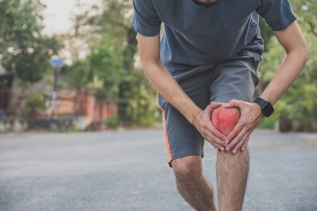 Corridore dell'uomo che fa jogging per l'esercizio al mattino ma dolore al ginocchio durante la corsa, sport e salute