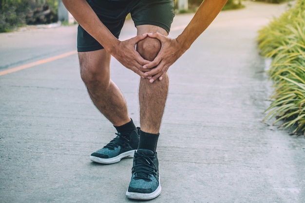 Corridore dolore al ginocchio durante la corsa, le persone lo sport sano