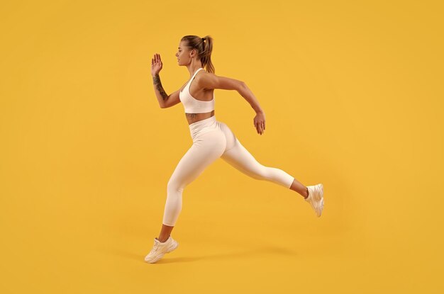 Corridore donna sport energetico in esecuzione su sfondo giallo