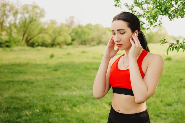 Corridore femminile che installa musica sul suo telefono durante l'allenamento di mattina