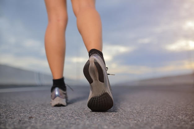 Corridore femminile che si prepara a fare jogging all'aperto sulla strada della città