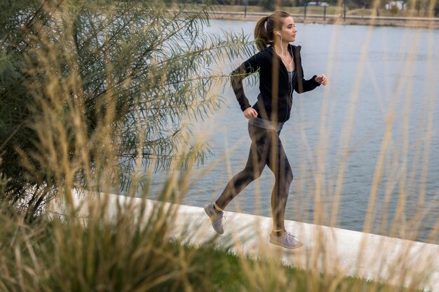 Corridore femminile vicino al lato del fiume