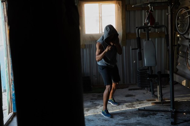 Corridore maschio che si esercita a boxe in uno studio di fitness