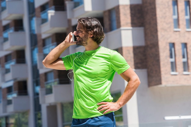 Corridore maschio che utilizza telefono cellulare all&#39;aperto