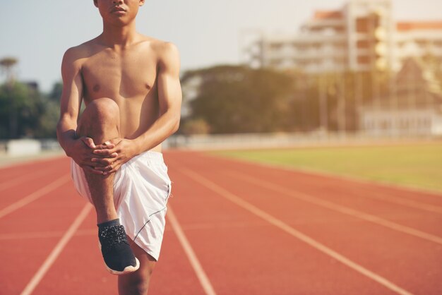 Corridore maschio facendo esercizio di stretching