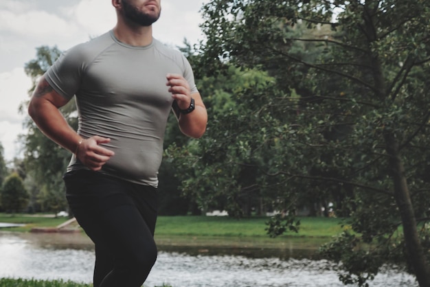 Corridore sportivo dell'uomo che corre nella formazione e nell'esercizio del parco