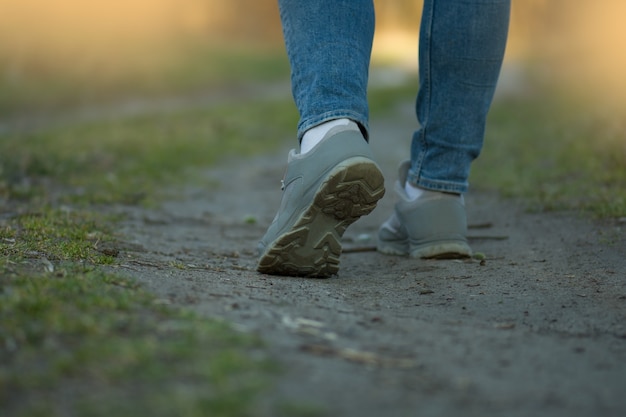 Corridore sportivo della donna in jeans e scarpe da ginnastica