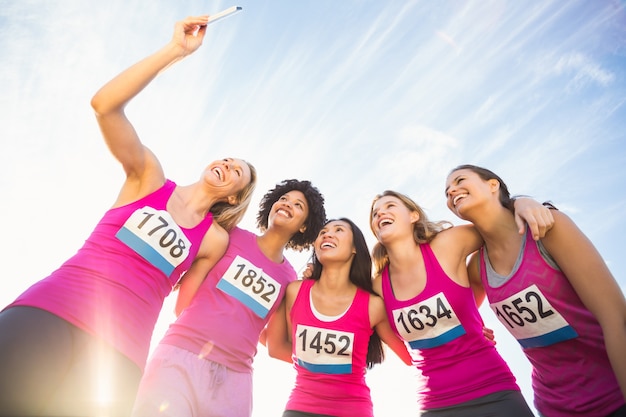 Corridori che sostengono la maratona del cancro al seno e fanno selfie