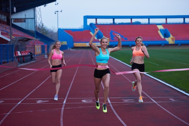 Corridori femminili che finiscono insieme la corsa atletica