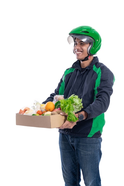 corriere indossa casco e giacca uniforme tenendo il cibo isolato su sfondo bianco