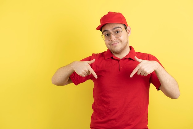 corriere maschio in uniforme rossa in piedi sopra il giallo.