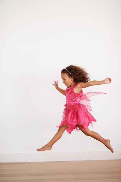 Corsa allo zucchero Ritagliata foto di una bambina esuberante che corre all'interno