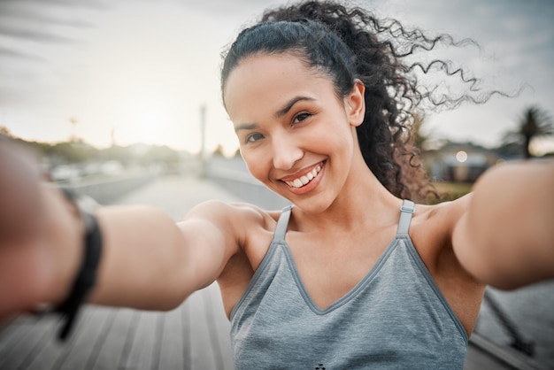 Corsa mattutina completata. Ritratto ritagliato di un'attraente giovane atleta femminile che si fa selfie durante la sua corsa mattutina all'aperto.