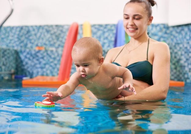 Corsi di nuoto per i più piccoli neonato con la mamma in piscina durante l'allenamento