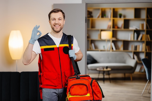 Corso di primo soccorso Un giovane paramedico maschio con una borsa sulle spalle è in piedi in un'aula prima di una lezione