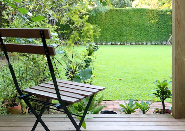 Cortile di prato verde brillante erba con una sedia di legno in primo piano