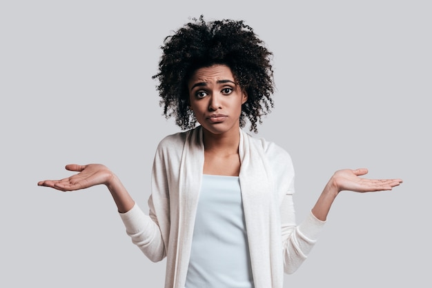 Cosa fare? Frustrato giovane donna africana in abbigliamento casual gesticolando e facendo la faccia