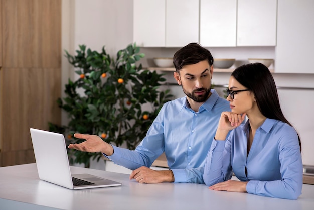 Cosa ne pensi Giovani colleghi di lavoro attivi seduti in cucina mentre discutono del loro progetto di business