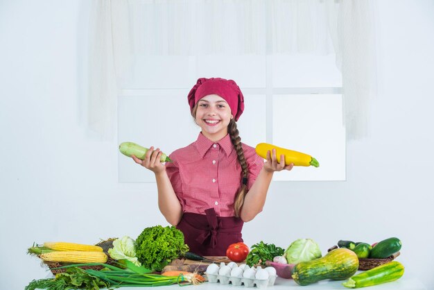 Cosa scegliere bambino che si diverte con il cibo verdure in cucina Bambino e verdure Mangiare sano e concetto di stile di vita Ragazza di cibo vegetariano verde con mais pieno di vitamine dieta e salute