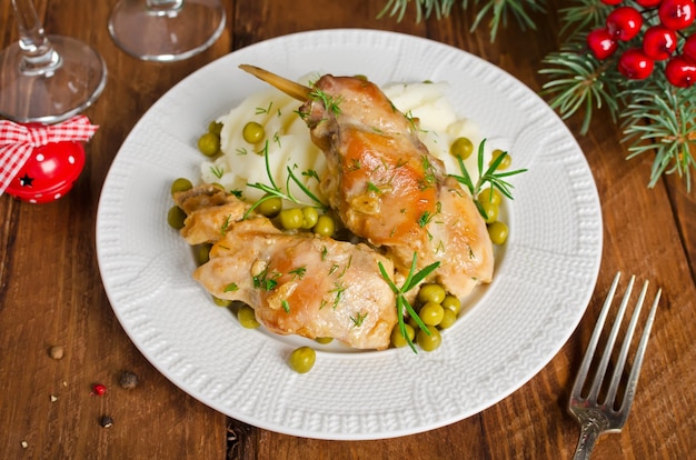 Cosce di coniglio al forno con patate e rosmarino. Stile rustico