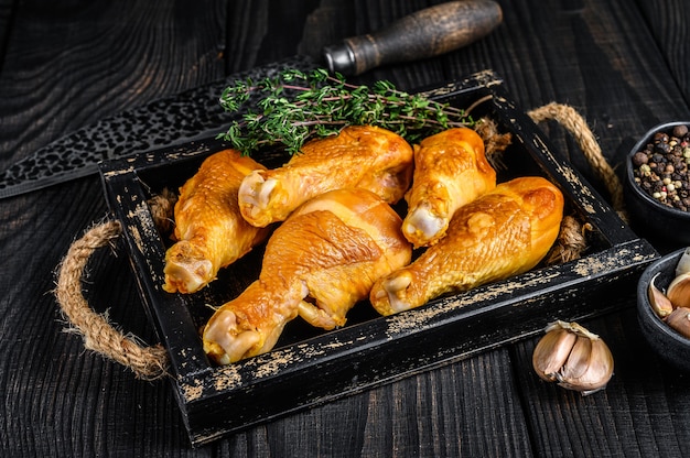 Cosce di coscia di pollo affumicate con erbe e spezie sulla tavola di legno. Vista dall'alto.