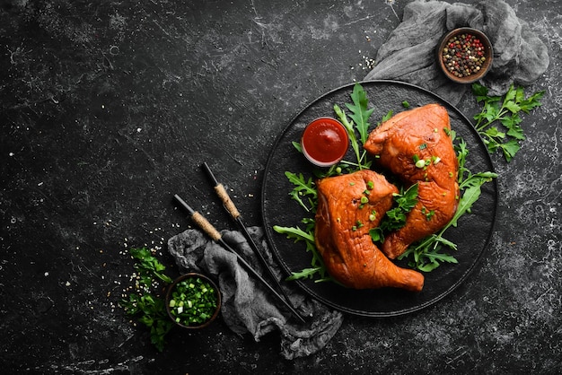 Cosce di pollo affumicate con ketchup su una lastra di pietra nera Vista dall'alto Spazio libero per il testo