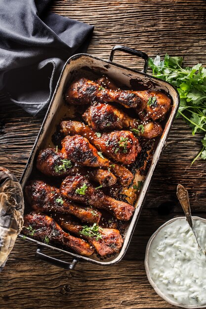 Cosce di pollo alla griglia arrosto e barbecue in padella con salsa tzaziki erbe e decorazione.