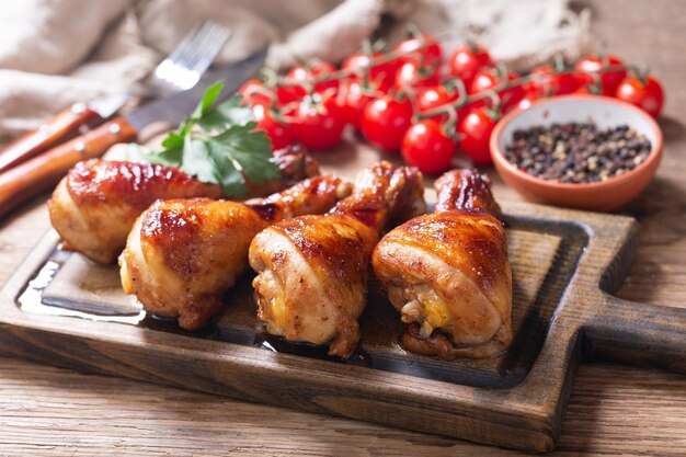 Cosce di pollo alla griglia con prezzemolo su tavola di legno