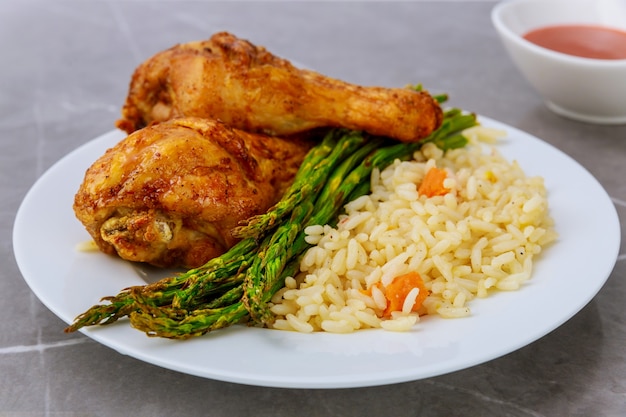 Cosce di pollo alla griglia con riso, asparagi e salsa di bufala.