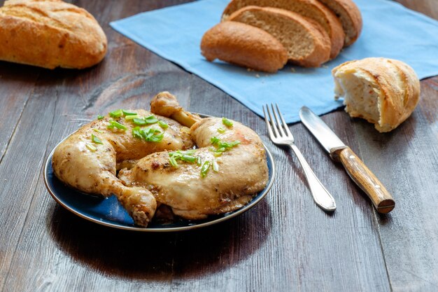 Cosce di pollo con pane sul piatto di colore blu