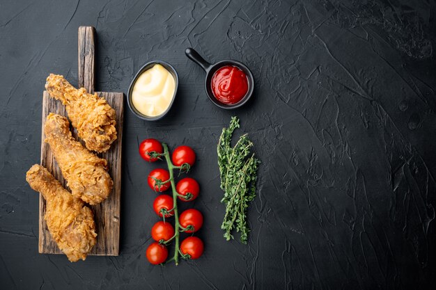 Cosce di pollo croccanti fritte, parti di bacchetta su sfondo nero