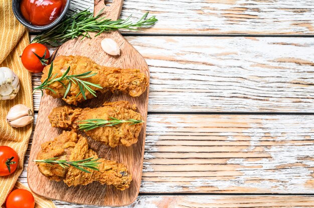 Cosce di pollo croccanti fritte su un tagliere