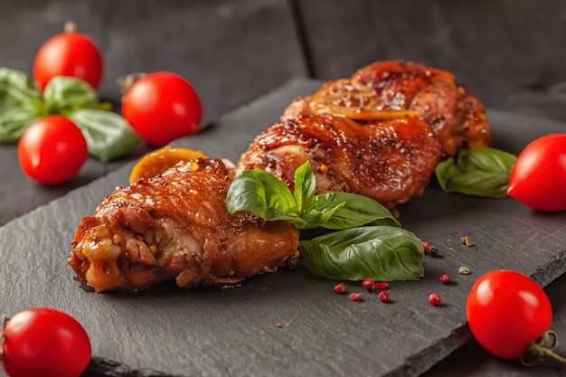 Cosce di pollo e basilico su una tavola nera