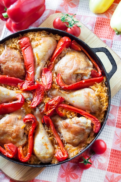 Cosce di pollo e cosce al forno su un letto di riso e peperone rosso