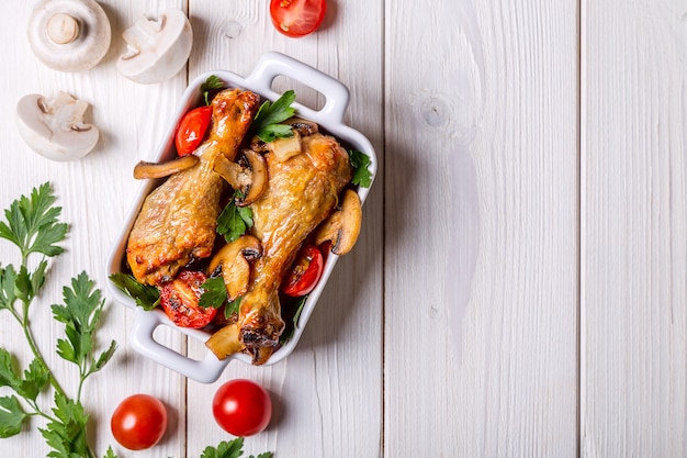 Cosce di pollo fritte con funghi e pomodori.