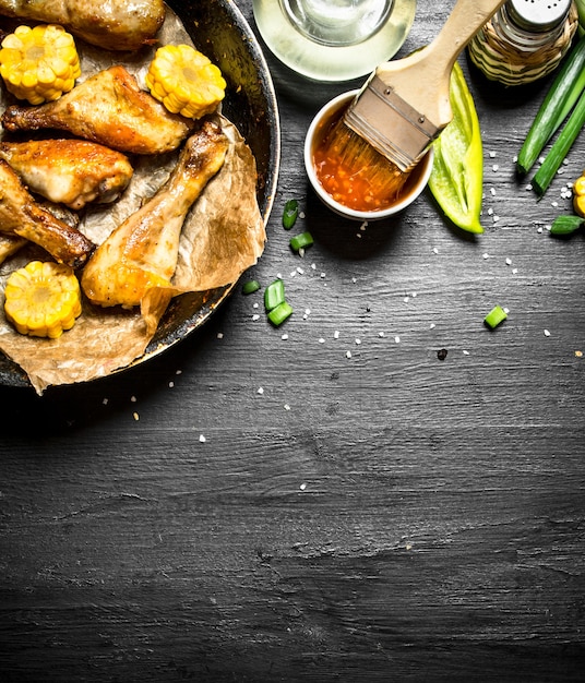 Cosce di pollo fritte con pezzi di mais e salsa di pomodoro.