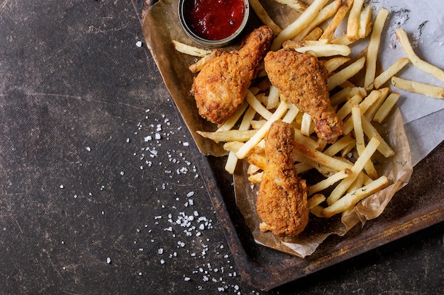 Cosce di pollo fritto con patatine fritte