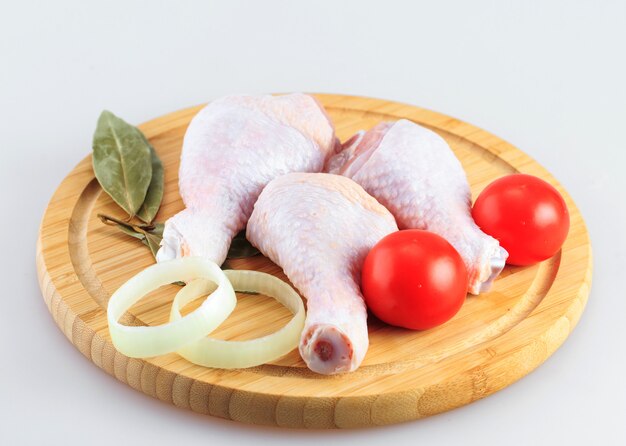 Cosce di pollo grezze su uno sfondo bianco