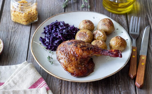 Coscia d'anatra al forno con patate e cavolo rosso